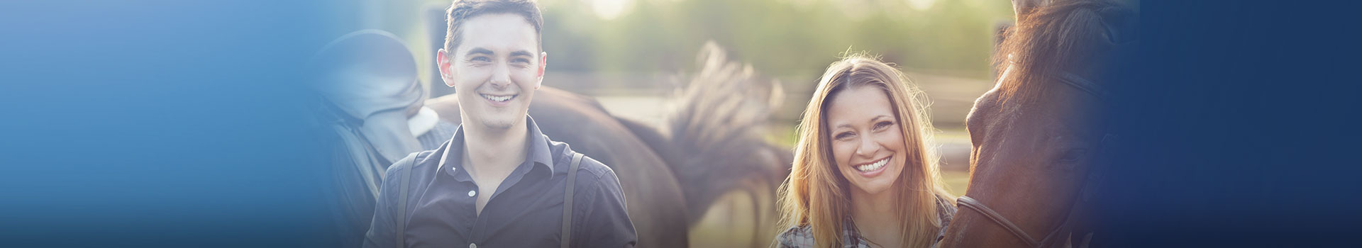 young man and woman standing outside next to horses (1)